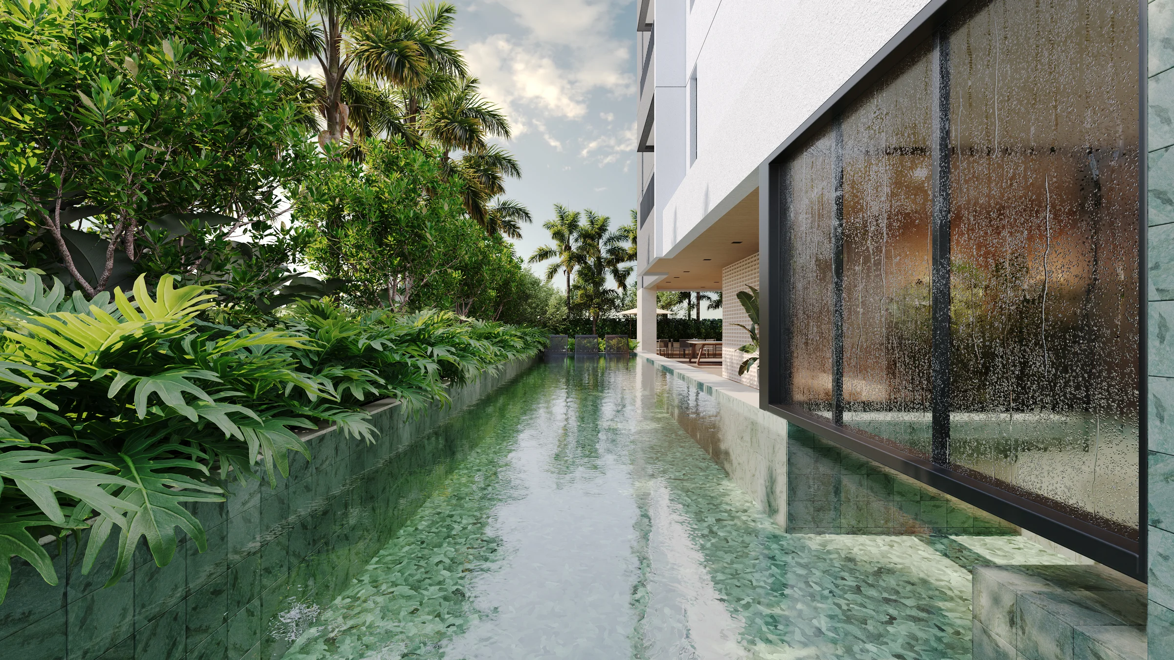 Piscina com raia cercada por vegetação tropical e cascata de vidro
