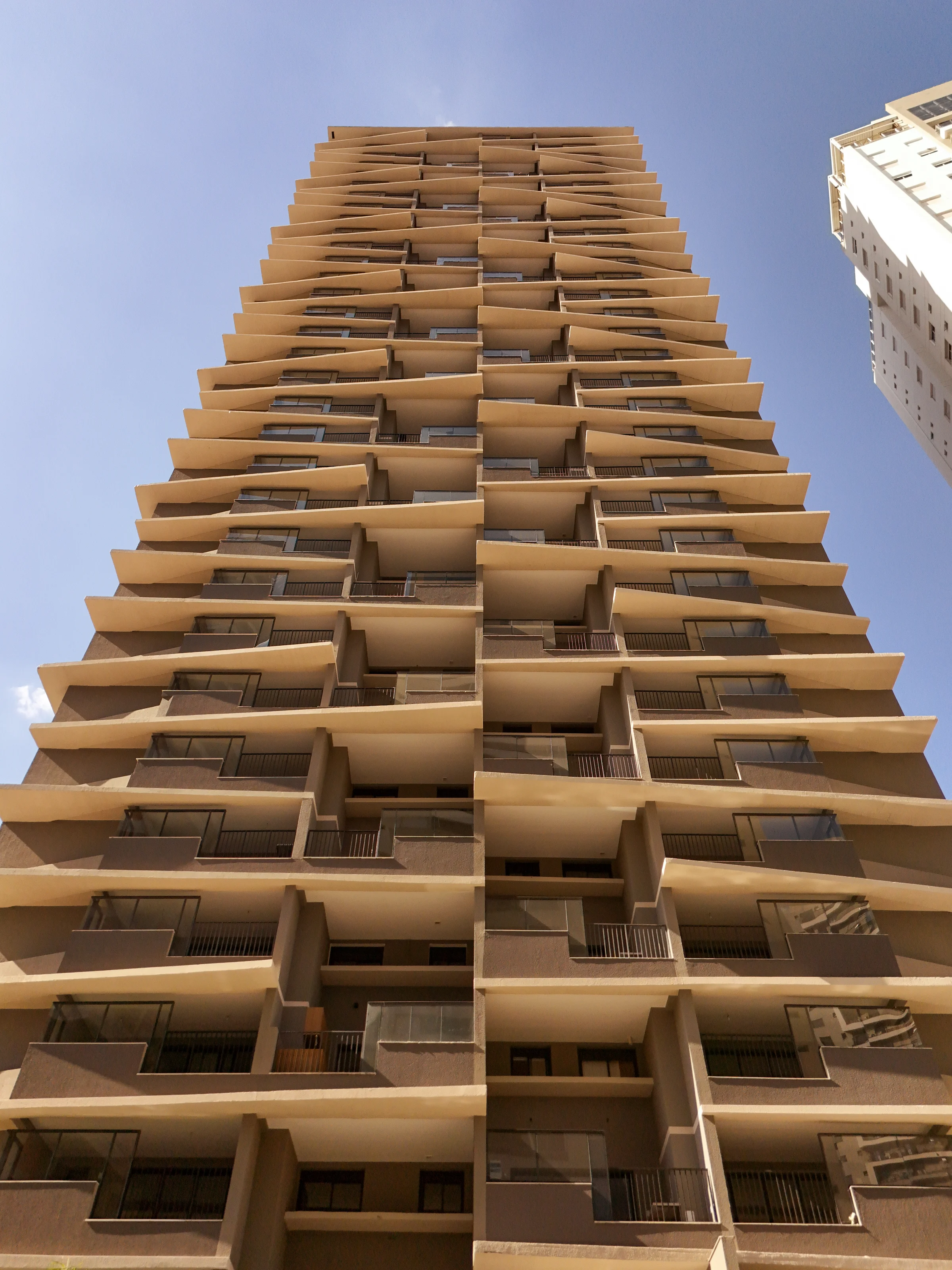 Fachada frontal completa do edifício Azure Compact Life com brises dinâmicos e varandas