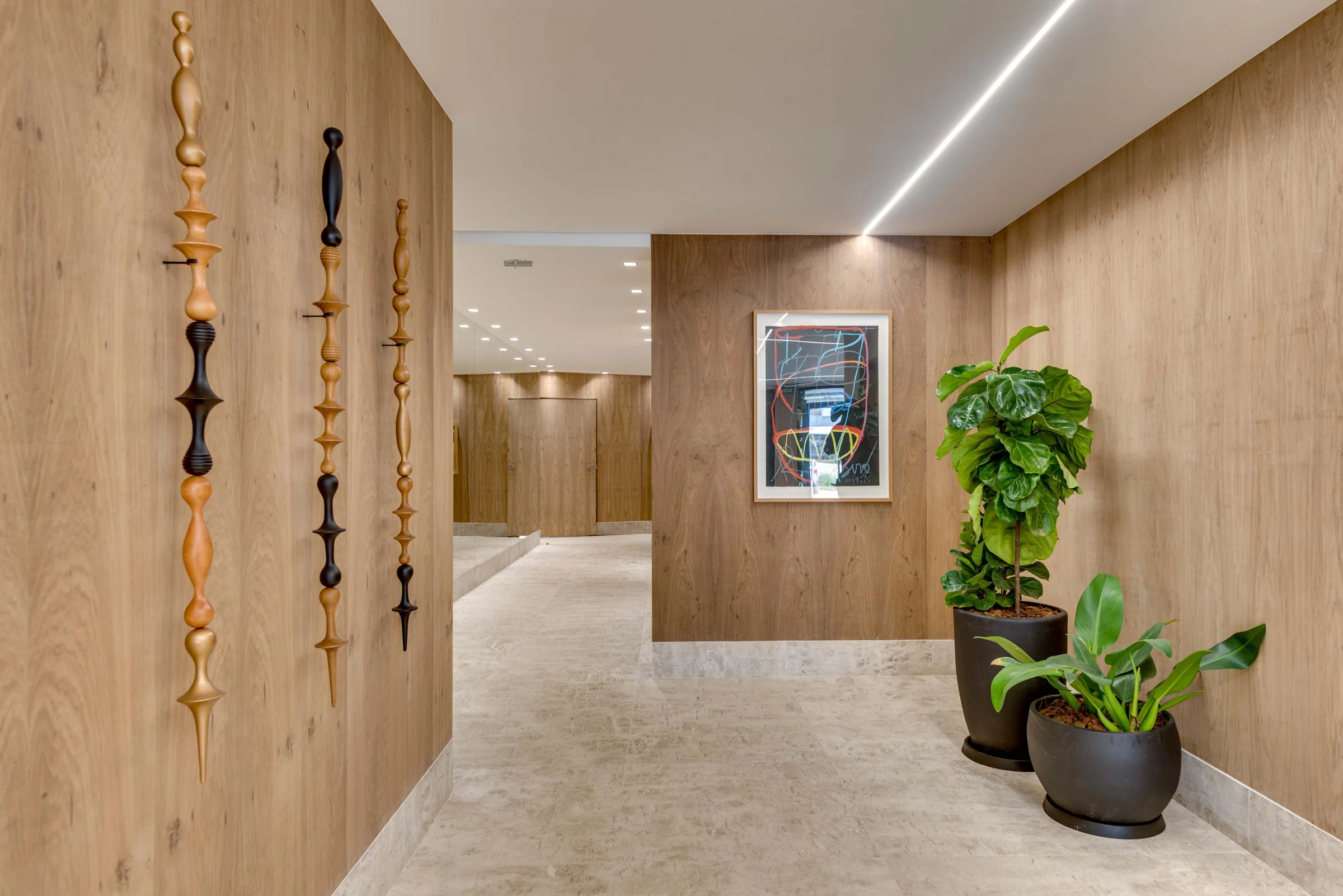 Foto do corredor de acesso com painel de madeira e plantas